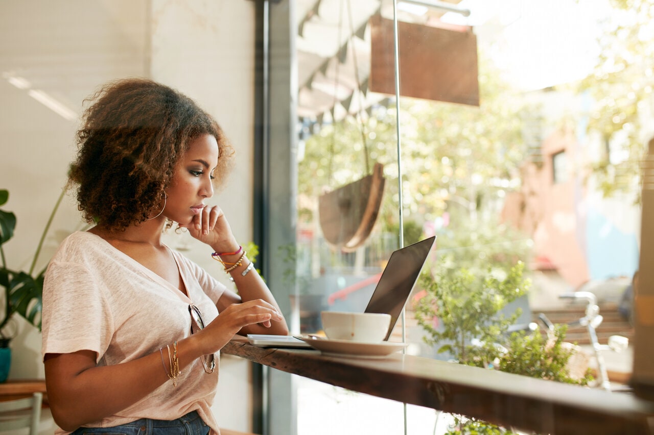person sittin on a seat with laptop computer in lap